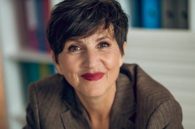 Good-looking businesswoman. Pretty mature woman smiling nicely and looking positive