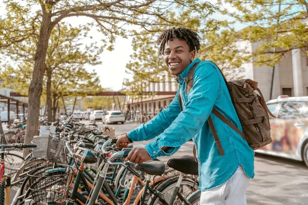 Optimism Happy Dark Skinned Guy Backpack Touching Bike Choosing Many — Stok Foto