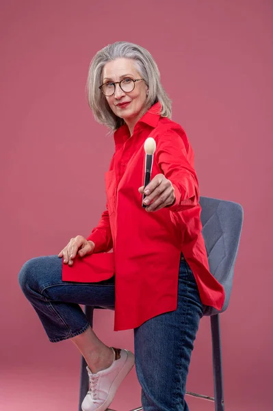 Makeup Woman Red Shirt Holding Face Brush Streching Her Hand — Stok fotoğraf