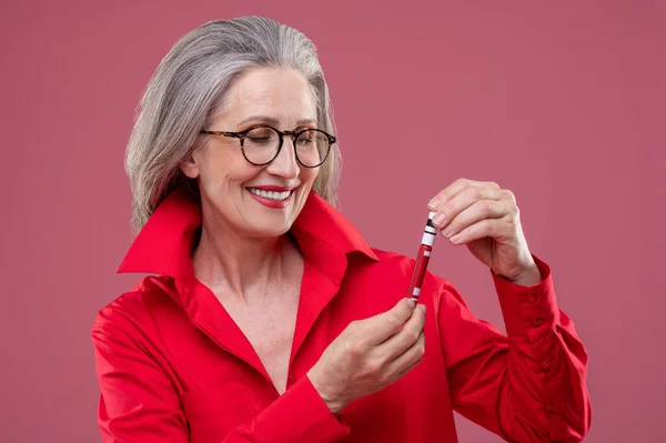 Makeup Woman Red Bright Shirt Holding Lip Gloss Looking Contented — ストック写真