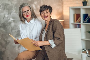 Business partners. Mid aged good-looking women working together in the office