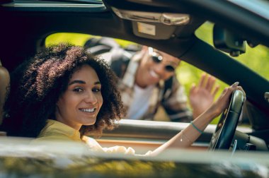 Hitchhiker. Young man and woman talking on the road and smiling