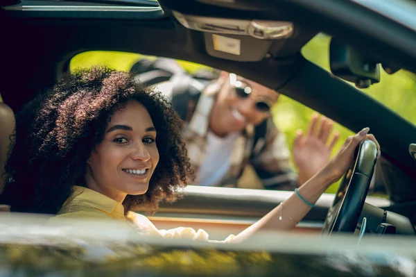 Hitchhiker. Young man and woman talking on the road and smiling