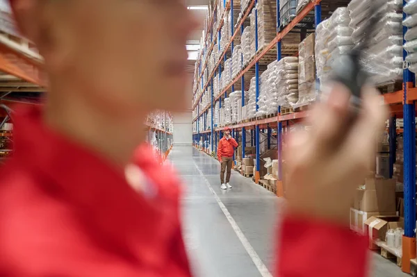 Storehouse Worker Standing Shelves Cargo Boxes Talking His Colleague Walkie — Foto de Stock