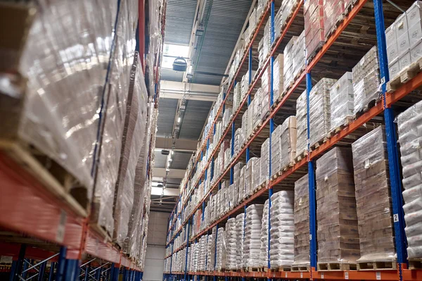 Heavy-duty shelving units with boxed packaged goods stacked on the pallets in the storage room