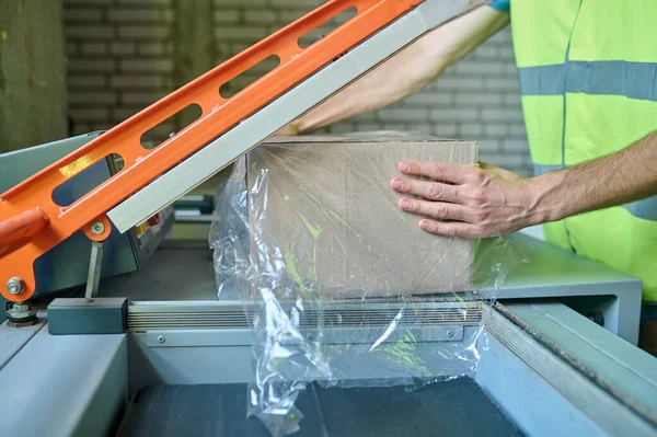 Cropped Photo Storehouse Employee Placing Cardboard Box Film Wrapping Machine — Stockfoto