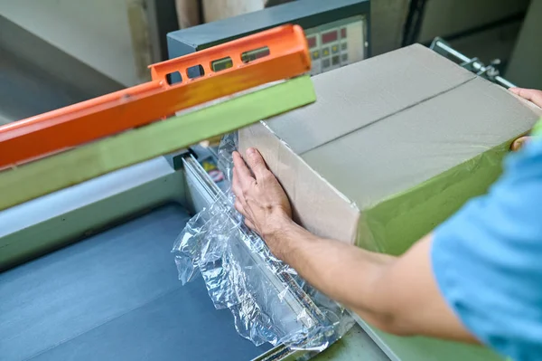 Cropped Photo Warehouse Worker Putting Cardboard Box Film Wrapping Machine — Photo