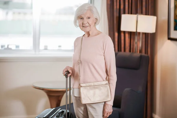 Arrival Good Looking Senior Woman Standing Suitcase Hotel Room — Stok fotoğraf