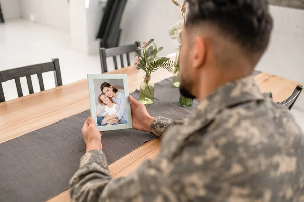 Uniformed Man Sitting Alone Kitchen Table Family Photo His Hands — 스톡 사진