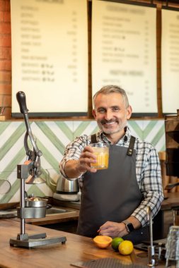 Orange fresh. Man in plaid shirt standing with a glass of orange fresh