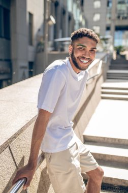 Man in the street. Dark-skinned young guy standing outside in the living-area