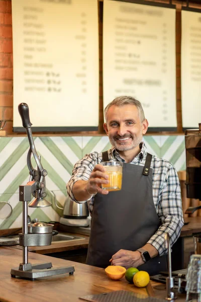 Orange fresh. Man in plaid shirt standing with a glass of orange fresh