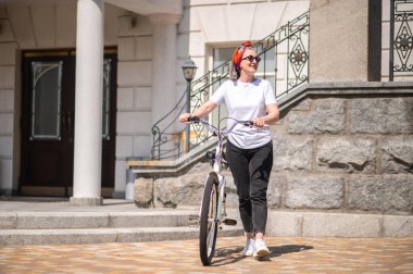Summer ride. Good-looking mature woman with a bike on a summer day