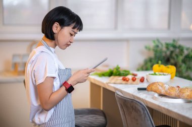 Dinner time. Woman cooking something vegetarian in the kitchen