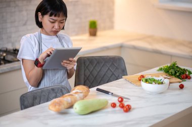 Dinner time. Woman cooking something vegetarian in the kitchen