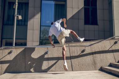 Motion. Young man in white tshirt jumping and looking energized