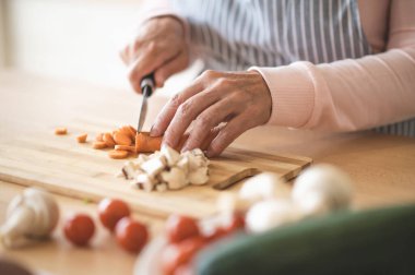 Making salad. Close up of woman cutting vegetables