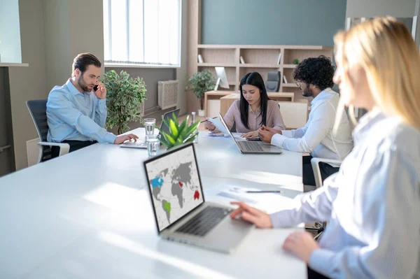 Work in progress. People working in the office and looking involved