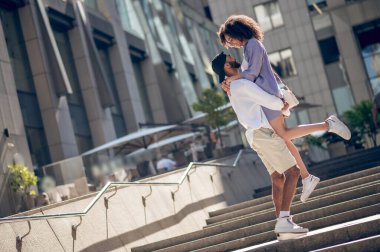 Happiness. Young man hugging his girlfriend and both looking happy
