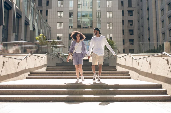 Happy couple. Cute couple walking hand in hand and looking happy