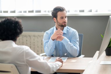 Discussion. Two young businessmen discussing something in the office