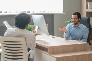 Work on project. Two businessmen looking busy while discussing project in the office