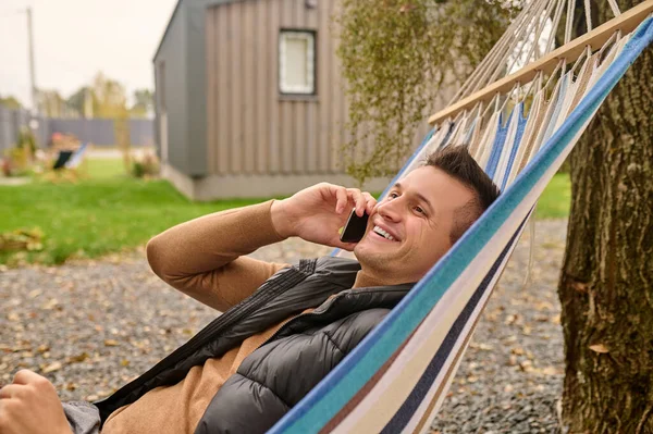 Smiling Joyful Attractive Young Male Holidaymaker Lying Alone Hammock Phone — Fotografia de Stock