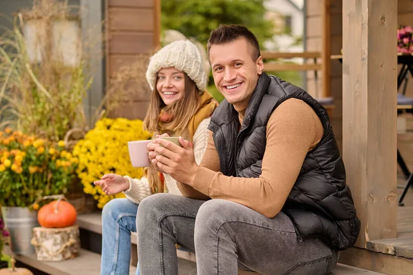 Joyous Man His Female Companion Sitting Porch Coffee Mugs Hands — Stock Photo, Image