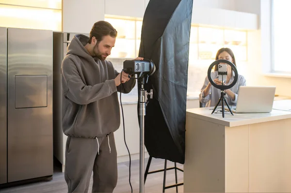 Videooperatör Installera Professionell Belysningsutrustning Framför Kvinnan Sitter Vid Den Bärbara — Stockfoto