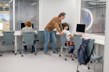 Okulda sınav var. Sınavda öğrencileri denetleyen öğretmen.