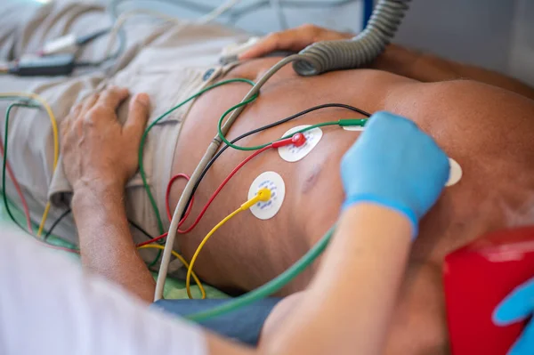 医疗工作者在心电图中倾听男性病人心跳的剪影 — 图库照片