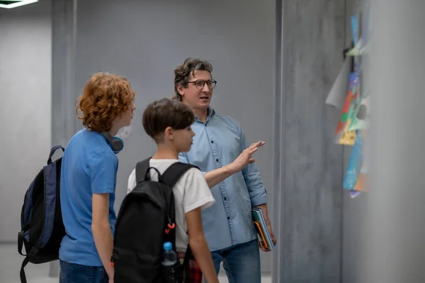 Schoolboys Backpacks Shoulders Standing Corridor Wall Listening Explanations Teacher — Stock Photo, Image