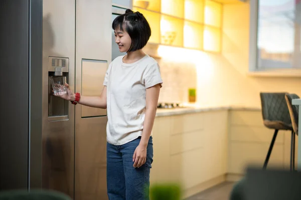 Усміхнена Задоволена Молода Жінка Стоїть Кухні Кладе Контейнер Під Холодильник — стокове фото