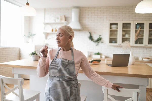 Blonde Reife Hausfrau Lehnt Sich Auf Den Speisestuhl Während Sie — Stockfoto