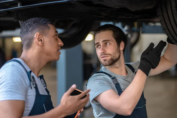 Team Auto Repair Workers Discussing Condition Tyres Customer Car — Stock Photo, Image