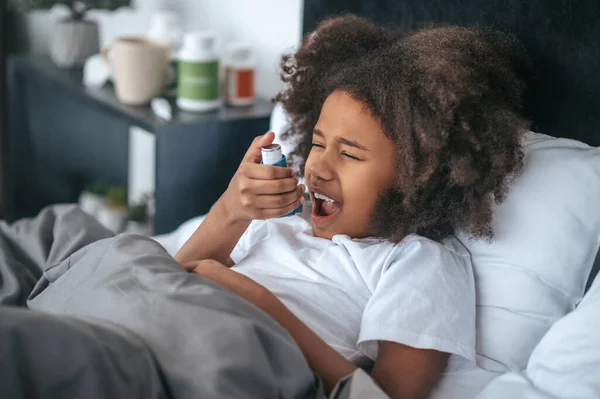 Angina Curly Haired Gorl Sparying Medicine Her Throat — Stock Photo, Image