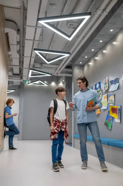 Pupil Smartphone Standing Corridor Wall While His Schoolmate Conversing Schoolteacher — Stock Photo, Image