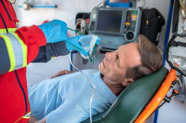 Experienced Ambulance Doctor Putting Oxygen Mask Male Patient Lying Stretcher — Stock Photo, Image