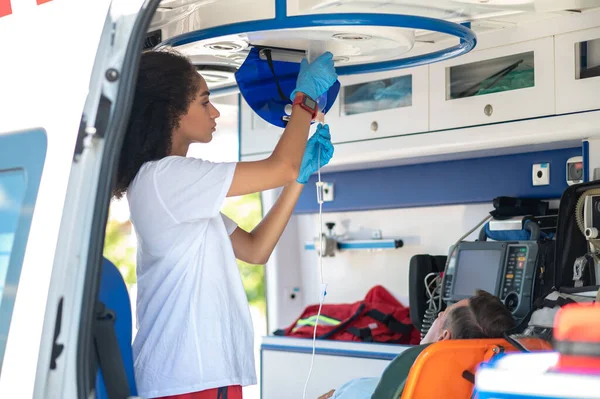 Sanitäter Hängen Die Kochsalzflasche Der Decke Des Rettungswagens Über Dem — Stockfoto