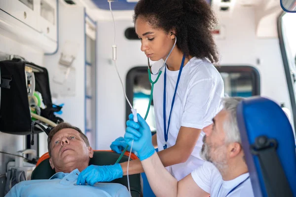 Paramedic Auscultating Patient Lying Stretcher Intravenous Infusion Procedure Performed Her Stock Image