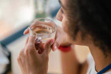 Sabah kahvesi. Kahve içen genç bir kadının yakın plan fotoğrafını çek.