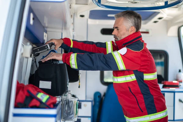 Vue Latérale Ambulancier Paramédical Sérieux Qui Monte Moniteur Ecg Mobile — Photo