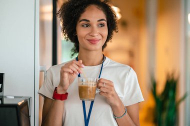 Kahve molası. Çalışırken kahve içen genç ve güzel bir kadın.