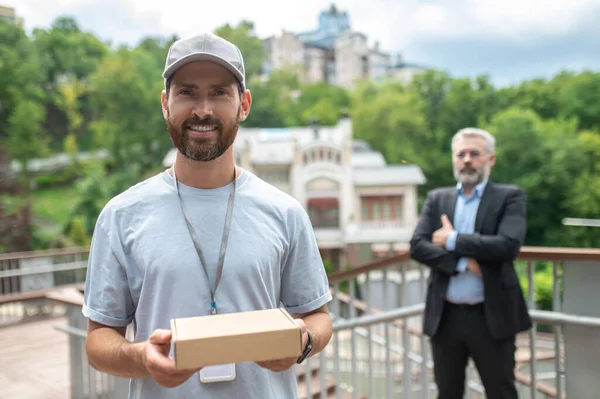 Teslimat Servisi Genç Erkek Kurye Kutuyu Olgun Adamına Veriyor — Stok fotoğraf