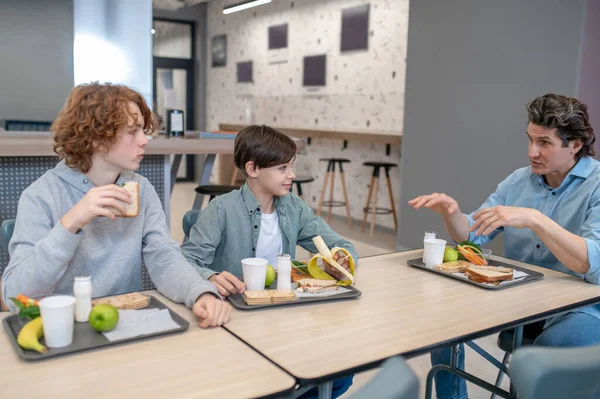 Schoolboys Seated Dining Table School Canteen Listening Teacher — Stock Photo, Image