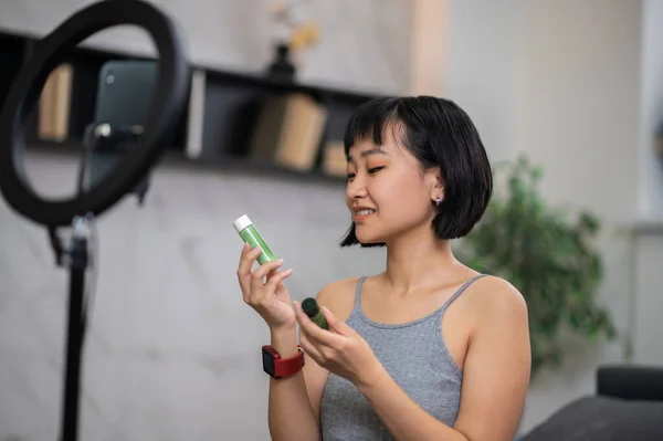 Sonriente Joven Vlogger Asiática Sosteniendo Par Productos Para Cuidado Piel — Foto de Stock