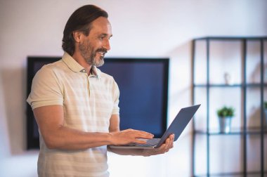 Evden çalışıyorum. Olgun, koyu saçlı, evden uzakta çalışan bir adam.