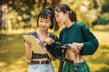 İnternette. Parktaki kızlar internetten bir şeyler izliyor ve ilgileniyorlar.