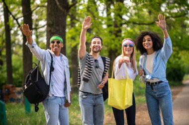 Otostopçular. Genç turistler orman yolunda otostop çekiyorlar.