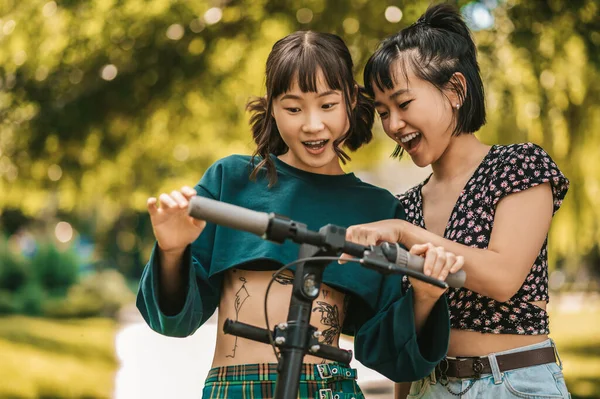 公園の女の子 公園でスクーターと二人の笑顔の女の子 — ストック写真